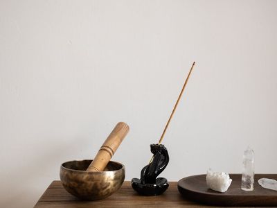 Incense sticks and a small bowl on a wooden floor.