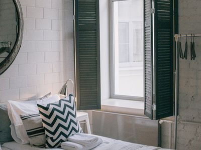 Minimalist silhouette of a person stretching in a bright room.