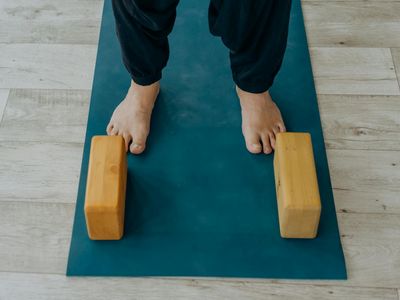 Yoga blocks and a strap neatly placed on a mat.